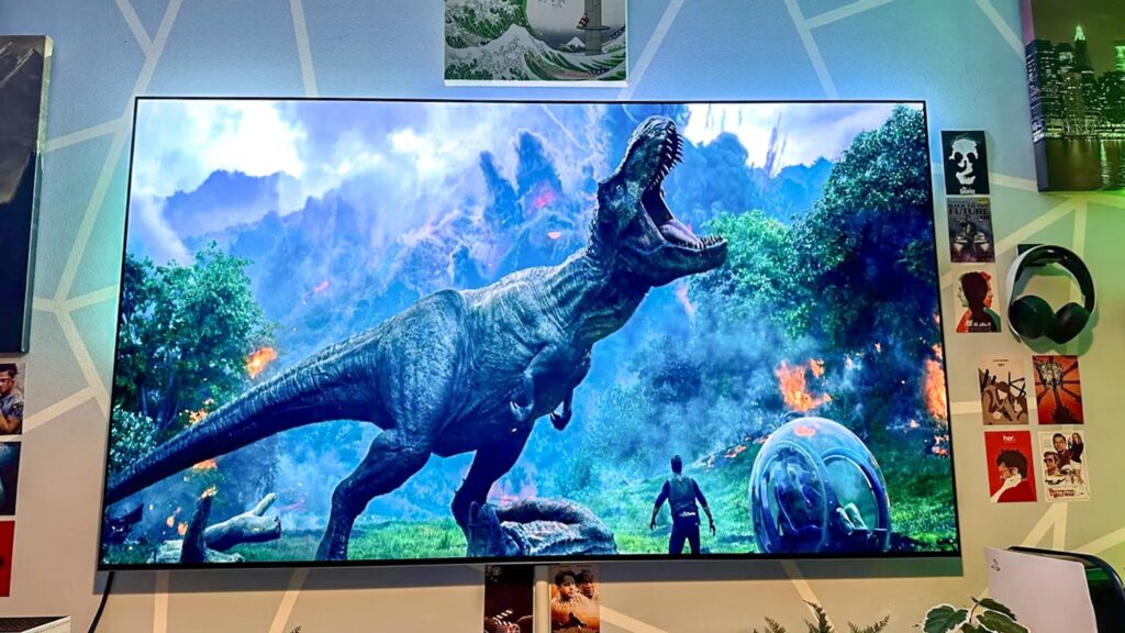 A stack of 4K Blu-ray cases beside a high-end LG OLED TV displaying a vivid movie scene—highlighting stunning audiovisual quality.