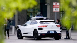 A sleek autonomous vehicle branded with Uber logos cruising through an urban environment, showcasing futuristic transportation.